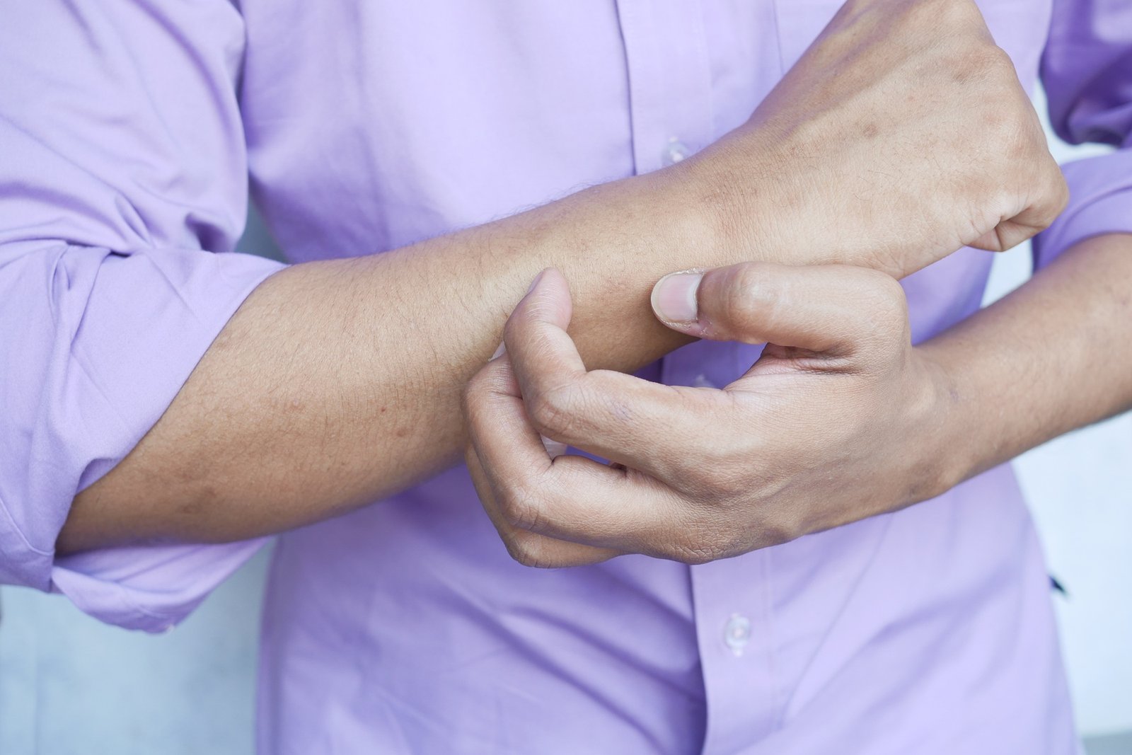 man suffering from itching skin, close up.